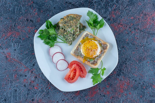 Ein weißer Teller mit köstlichem Toast mit Fleisch und Gemüse.