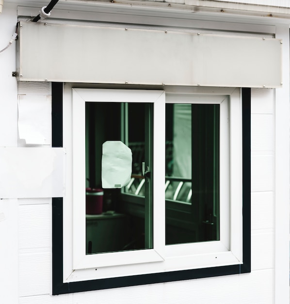 Ein weißes Shop-Signage-Modell über einem Shopfenster