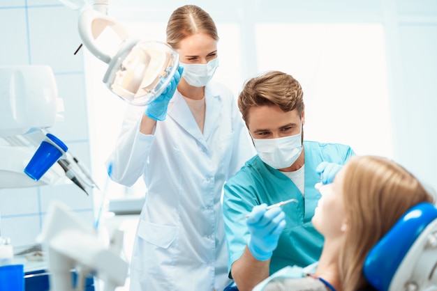 Ein zahnarzt und eine krankenschwester behandeln einen patienten in einer zahnarztpraxis. Premium Fotos