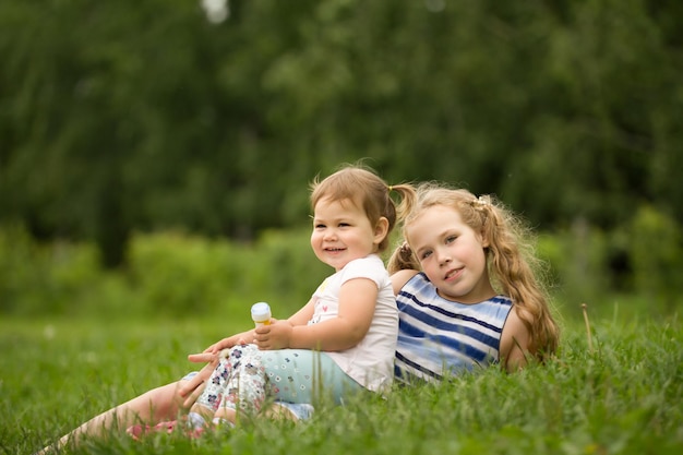 Ein zwei babys schwestern, die im außenporträt des parks spielen