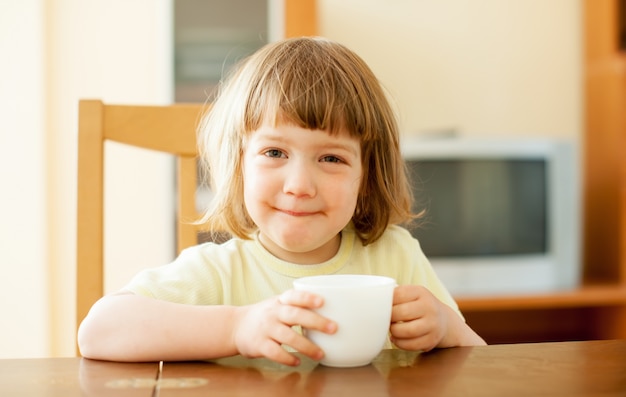 Ein zweijähriges Kind trinkt aus einem Becher
