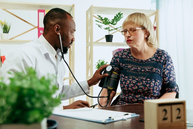 Eine ältere Frau, die einen Therapeuten in der Klinik besucht