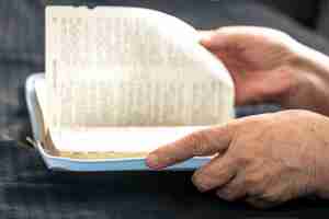 Kostenloses Foto eine ältere frau liest ein buch mit den händen und der nahaufnahme der bibel