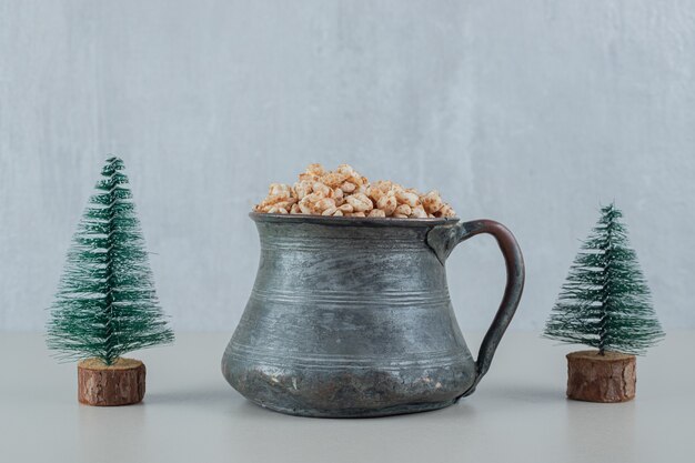 Eine alte Tasse voller gesunder Getreide mit Weihnachtsbäume