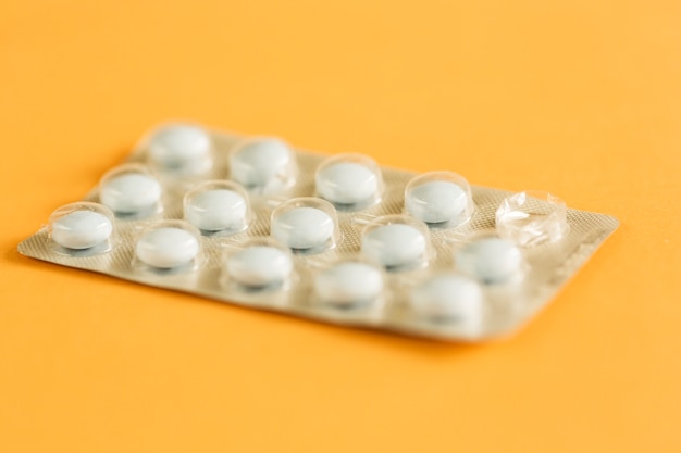 Eine benutzte Tablettenblisterpackung auf gelbem Hintergrund