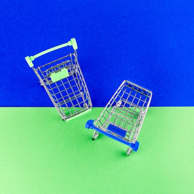 Eine Draufsicht auf zwei Einkaufswagen auf blauem und grünem Hintergrund