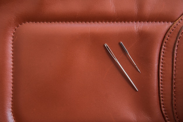 Eine Draufsicht auf zwei Nadeln auf braunem Leder