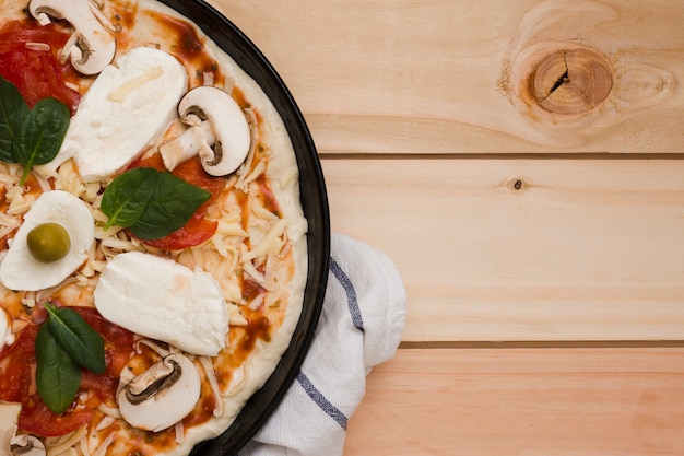 Eine Draufsicht der italienischen Pizza auf hölzernem Hintergrund