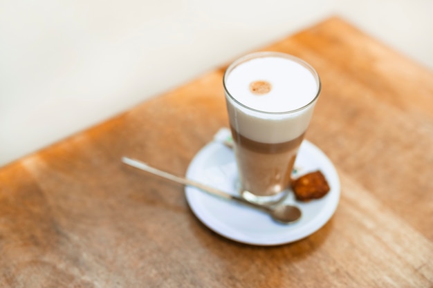 Eine Draufsicht des Cappuccinokaffees in einem transparenten Glas auf Tabelle