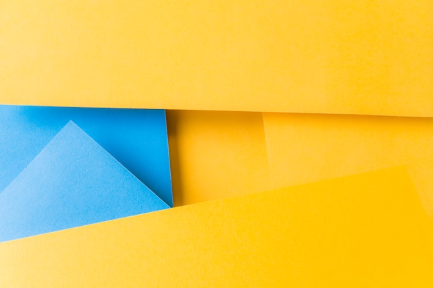 Eine Draufsicht des strukturierten Hintergrundes des gelben und blauen Papiers