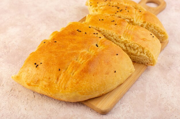 Eine Draufsicht gebackenes Brot heißes leckeres frisches geschnittenes auf Holzschreibtisch auf Rosa