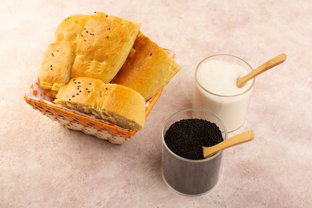 Eine Draufsicht gebackenes Brot heißes leckeres frisches geschnittenes in Brotbehälter zusammen mit Salz und Pfeffer auf Rosa