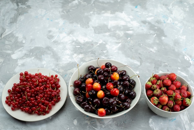 Eine Draufsicht Kirschen und Erdbeeren mit Preiselbeeren innerhalb der weißen Tellerbeere