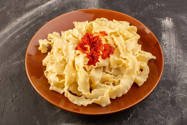 Eine Draufsicht kochte italienische Nudeln mit Tomatensauce innerhalb Platte