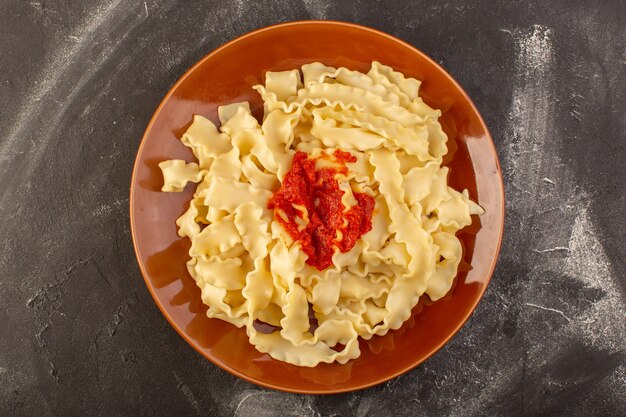 Eine Draufsicht kochte italienische Nudeln mit Tomatensauce innerhalb Platte