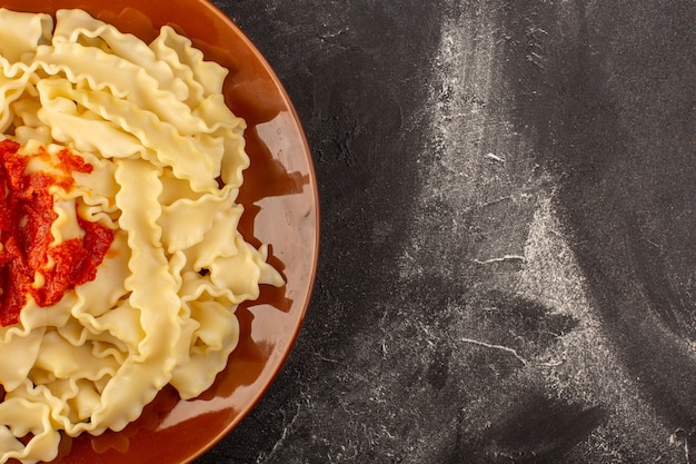 Eine Draufsicht kochte italienische Nudeln mit Tomatensauce innerhalb Platte