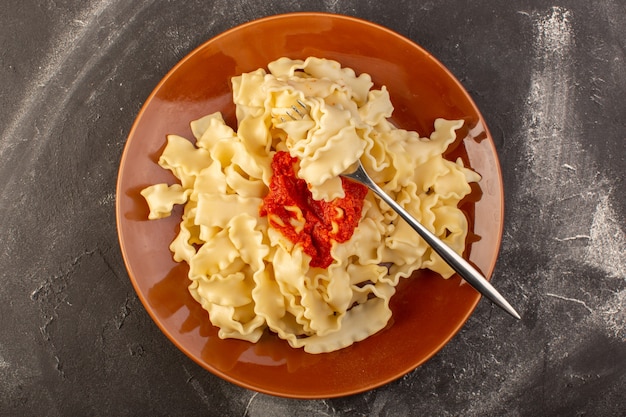 Eine Draufsicht kochte italienische Nudeln mit Tomatensauce innerhalb Platte