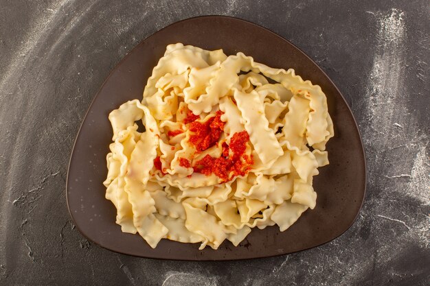 Eine Draufsicht kochte italienische Nudeln mit Tomatensauce innerhalb Platte