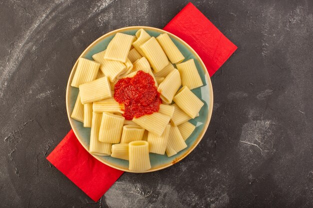Eine Draufsicht kochte italienische Nudeln mit Tomatensauce innerhalb Platte