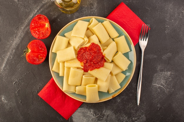 Eine Draufsicht kochte italienische Nudeln mit Tomatensauce innerhalb Tellerplatte