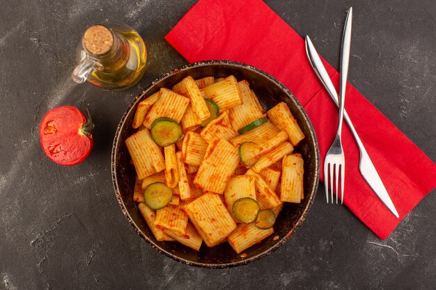 Eine Draufsicht kochte italienische Nudeln mit Tomatensauce und Gurke in der Pfanne