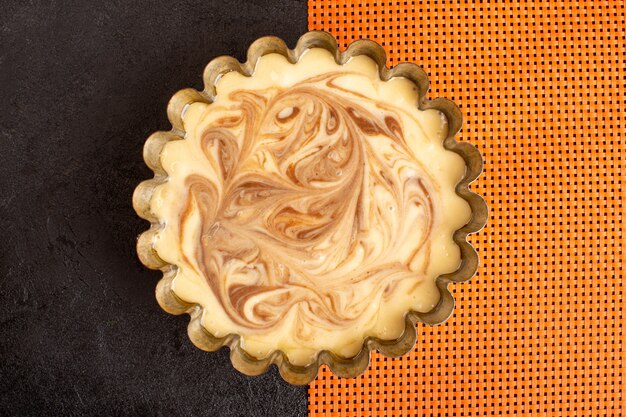 Eine Draufsicht köstlicher Kaffeekuchen süß köstlicher Zuckerbackkuchen süß auf dem dunklen und orange Schreibtisch