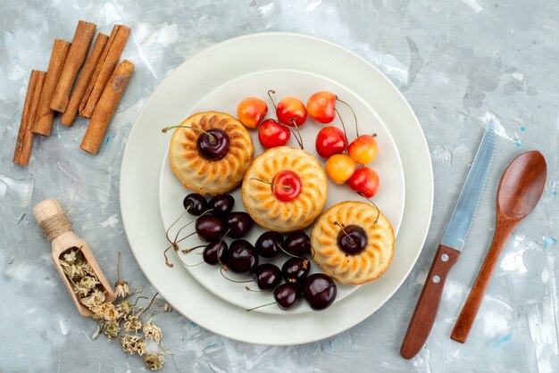 Eine Draufsicht leckere Kekse mit Kirschen-Keks-Dessert-Tee-Frucht