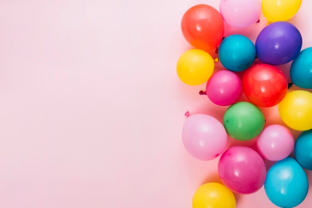 Eine Draufsicht von bunten Ballonen über rosa Hintergrund