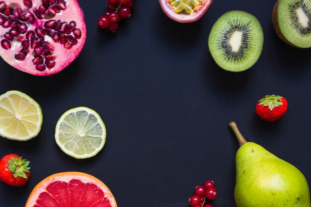 Eine Draufsicht von saftigen gesunden Früchten auf schwarzem Hintergrund