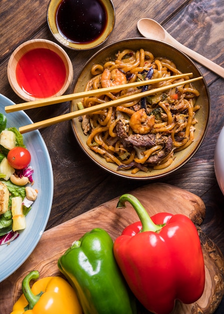 Eine Draufsichtschüssel mit thailändischem köstlichem Rindfleisch; Garnelen mit Udon-Nudeln und Saucen