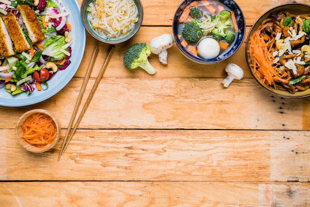 Eine erhöhte Ansicht des traditionellen thailändischen Lebensmittels mit Essstäbchen auf hölzernem Schreibtisch