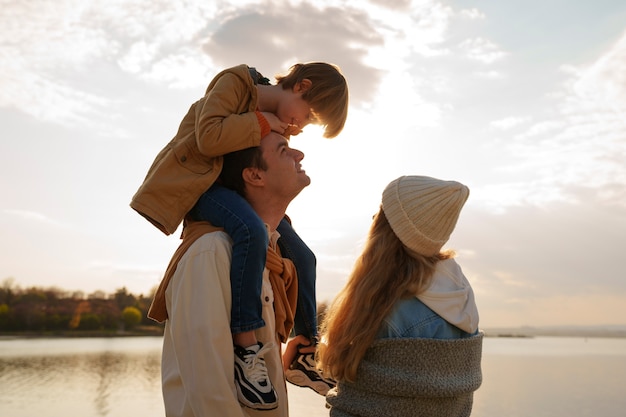 Kostenloses Foto eine familie in mittlerer aufnahme hängt auf einem steg