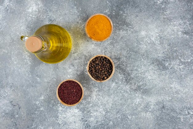 Eine Flasche Öl mit Holzschalen Paprika.