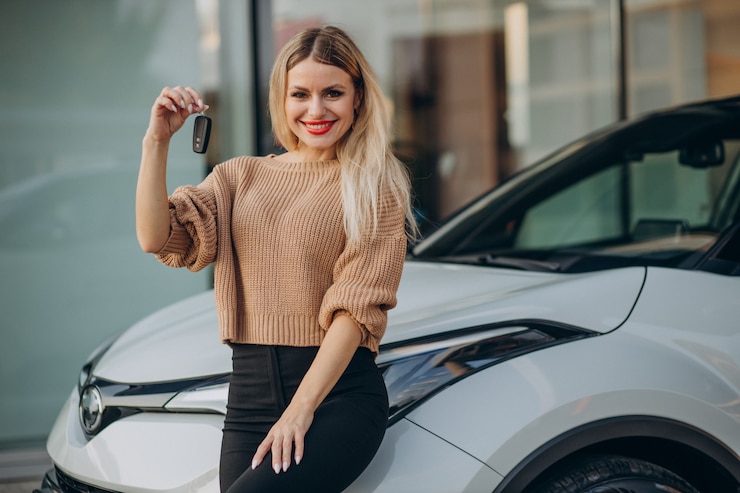 Kostenlose Foto eine frau hält die schlüssel zu ihrem neuen auto