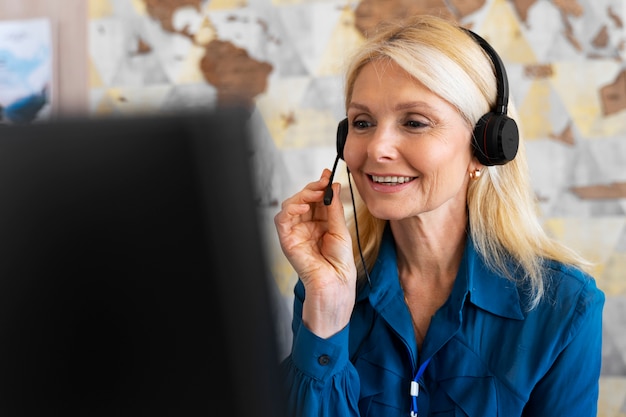 Eine Frau in mittlerer Aufnahme arbeitet im Büro eines Reisebüros