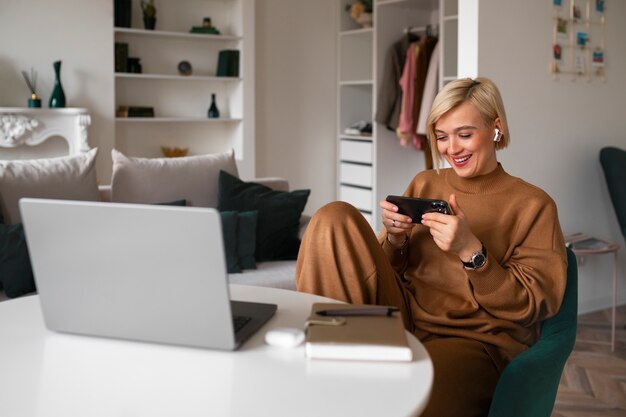 Eine Frau in mittlerer Aufnahme spielt mit ihrem Telefon