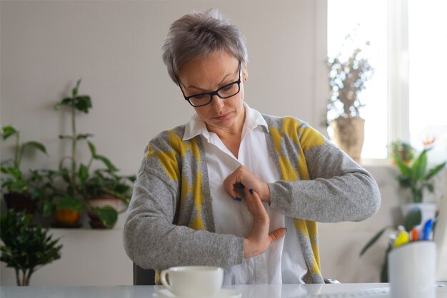 Eine Frau in mittlerer Aufnahme streckt sich am Schreibtisch