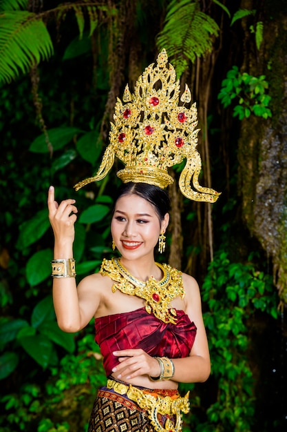 Eine Frau kleidete sich mit einem alten thailändischen Kleid am Wasserfall an.