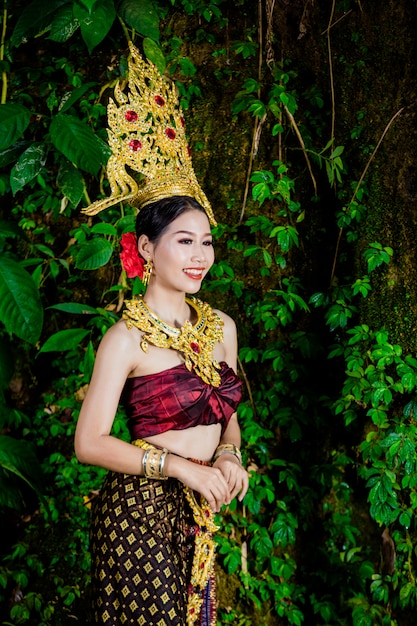 Eine Frau kleidete sich mit einem alten thailändischen Kleid am Wasserfall an.