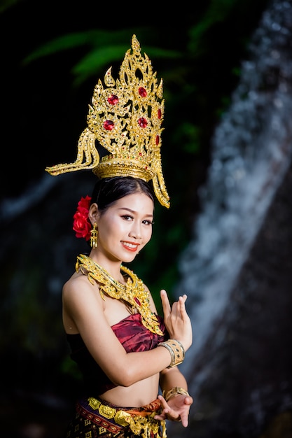 Eine Frau kleidete sich mit einem alten thailändischen Kleid am Wasserfall an.