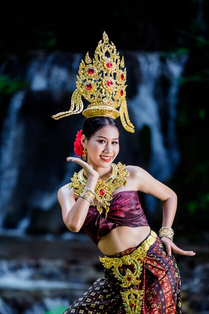 Eine Frau kleidete sich mit einem alten thailändischen Kleid am Wasserfall an.