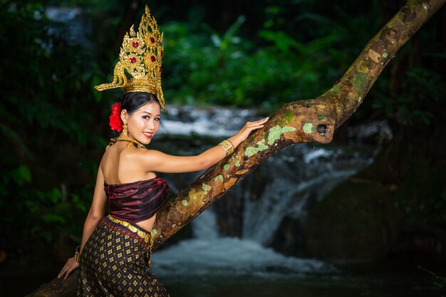 Eine Frau kleidete sich mit einem alten thailändischen Kleid am Wasserfall an.