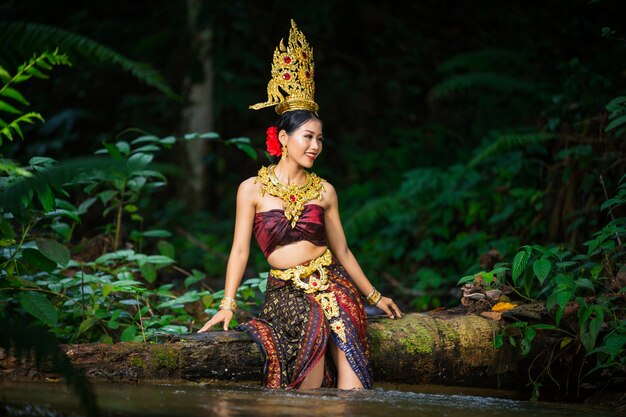 Eine Frau kleidete sich mit einem alten thailändischen Kleid am Wasserfall an.