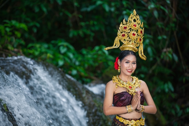 Eine Frau kleidete sich mit einem alten thailändischen Kleid am Wasserfall an.