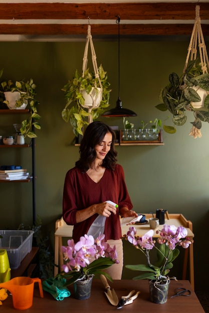 Kostenloses Foto eine frau kümmert sich um eine exotische orchidee