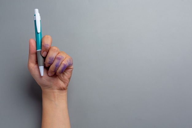 Eine Frau linke Hand mit einem Stift. Linkshänder Tag Konzept.