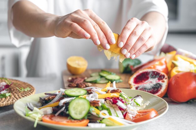 Eine Frau macht eine Salatnahaufnahme aus frischem Gemüse