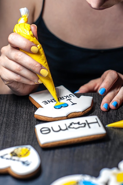 Kostenloses Foto eine frau macht patriotischen lebkuchen zur unterstützung der ukraine