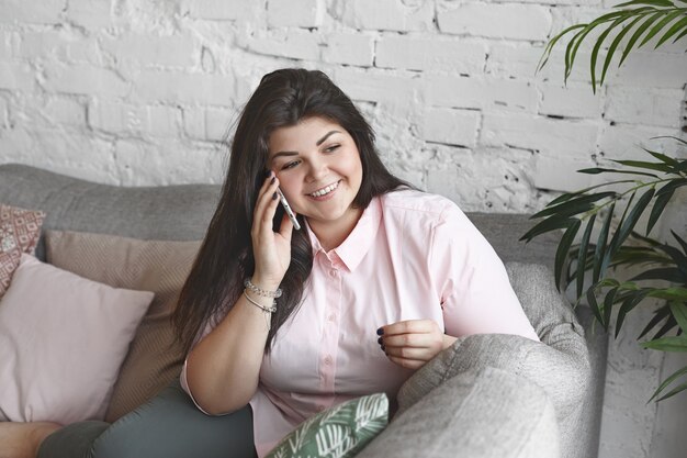 Eine Frau mit schönem Körper posiert auf der Couch