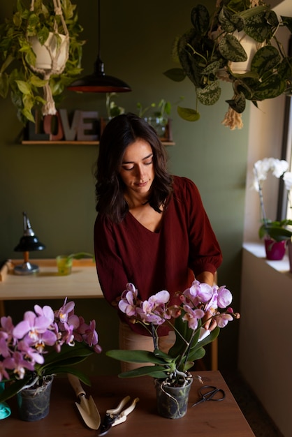 Kostenloses Foto eine frau schmückt ihr haus mit orchideen